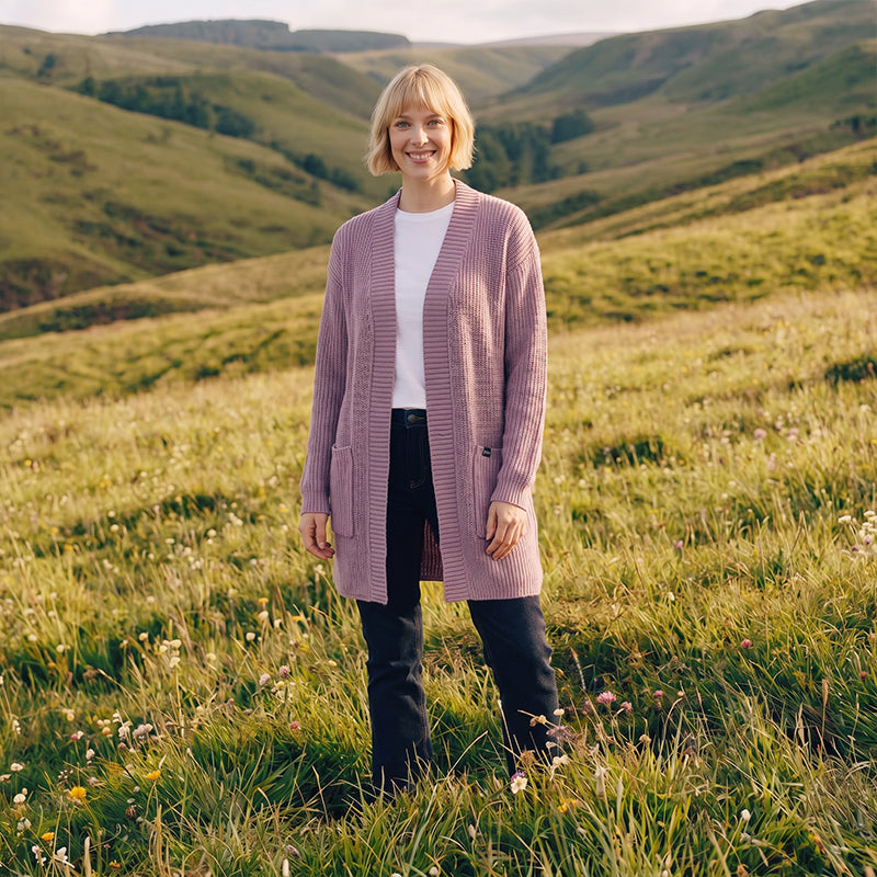 Woman standing in a field with rolling hills in the background